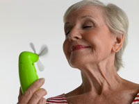 Photo: Older woman using hand-held fan